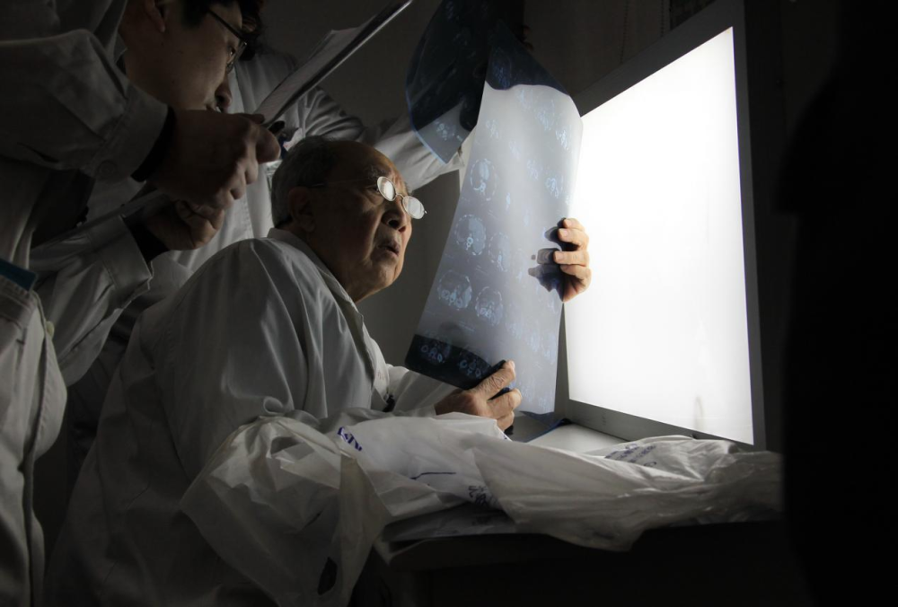 吴孟超带着学生仔细诊断患者病情,确定手术方案.王建民摄