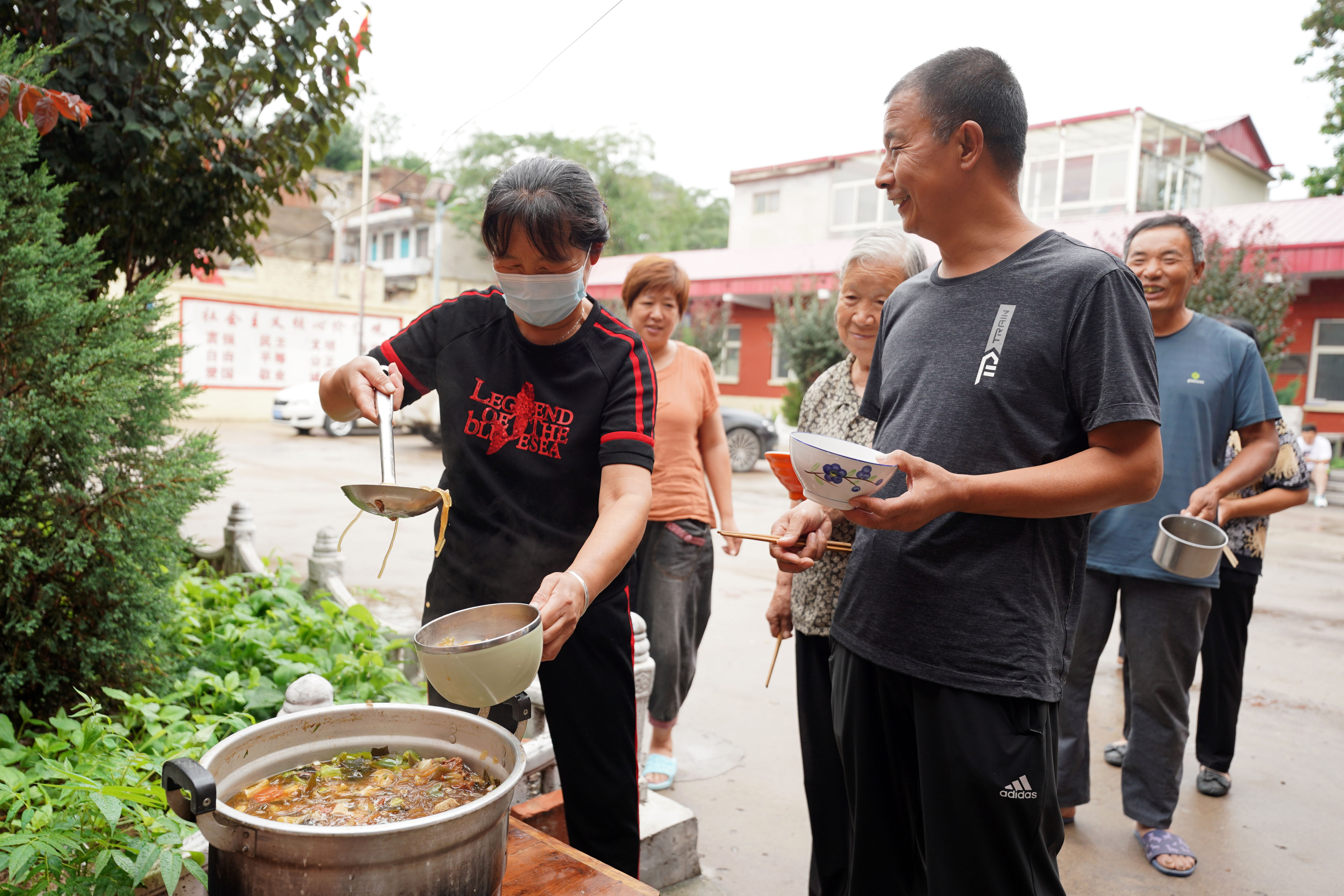 7月19日,村民在沙河市刘石岗乡渡口村一处临时安置点内打饭
