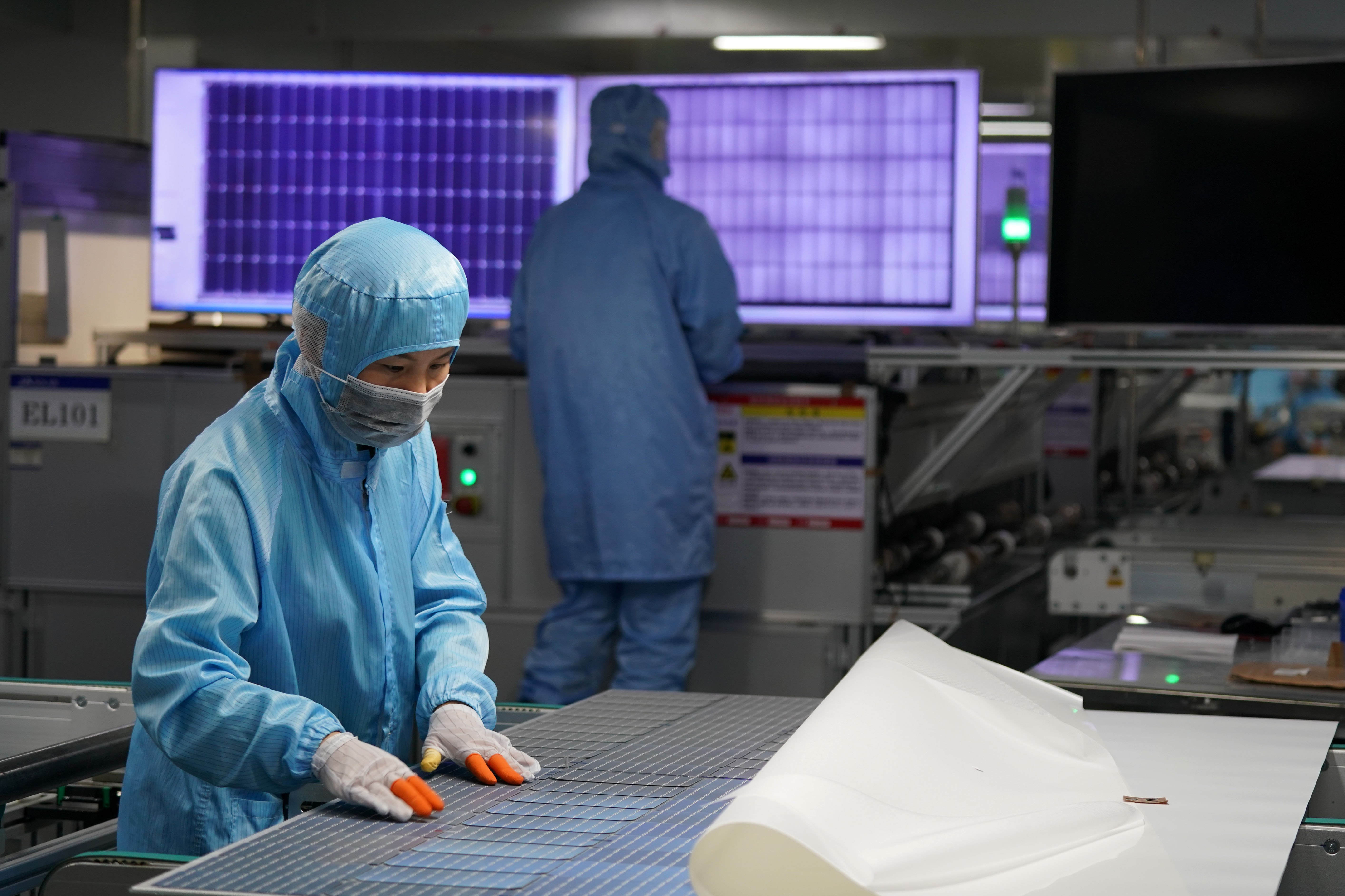 ↑7月21日,河北邢台一家太阳能有限公司工人在检测太阳能组件质量
