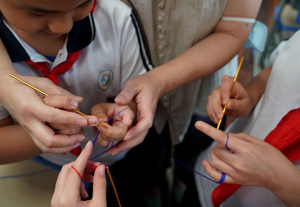 复兴东路第三小学的学生们在"乐系列"兴趣课上,体验学习钩针编织技艺